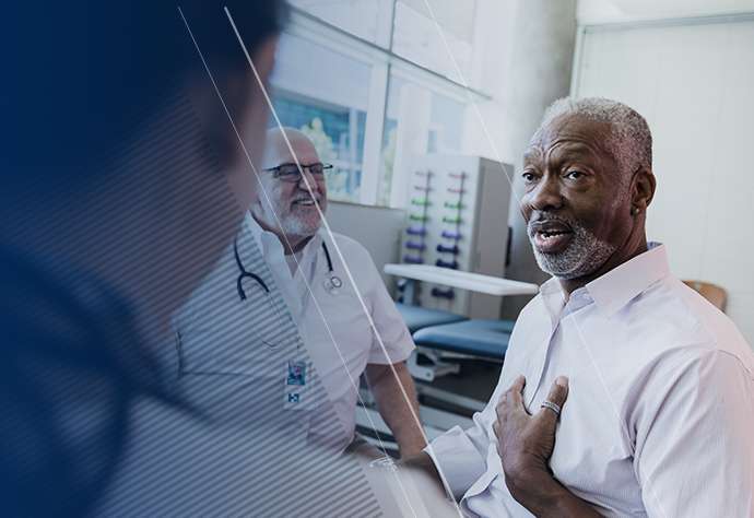 Man speaking with healthcare professionals (HCPs) while pointing at himself