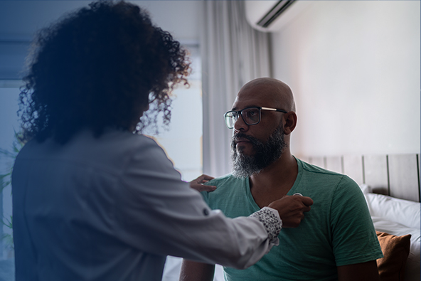 Healthcare professional (HCP) listening to a man's chest with a stethoscope